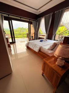 a bedroom with a bed and a table with a lamp at Giri Swari Homestay in Sidemen