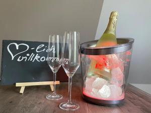 a bottle of wine in a container next to two wine glasses at Thüringer Wald-Zauber in Zella-Mehlis