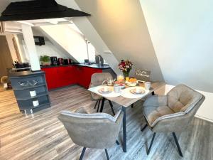 a dining room with a table and chairs and a kitchen at Thüringer Wald-Zauber in Zella-Mehlis +33 photos