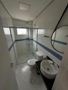 Un baño con lavabo, ducha e inodoro. en Frente ao Mar - Acorde Com o Barulho das Ondas apto 10, en Praia Grande