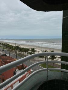 una vista de la playa desde el balcón de un edificio en Frente ao Mar - Acorde Com o Barulho das Ondas apto 10, en Praia Grande