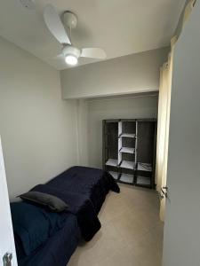 Un dormitorio con una cama y un ventilador de techo. en Frente ao Mar - Acorde Com o Barulho das Ondas apto 10, en Praia Grande