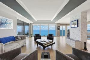 a living room with a couch and a table at Sophisticated Three-Bedroom Coastal Apartment with Fireplace in Naples