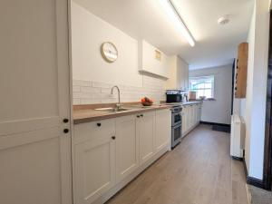 Una cocina con gabinetes blancos y un fregadero. en 2 Bed in High Lorton SZ136, en Lorton