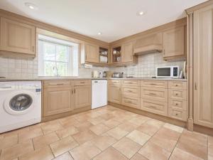 a kitchen with wooden cabinets and a washer and dryer at 4 Bed in Keswick oc-sz434 in Applethwaite