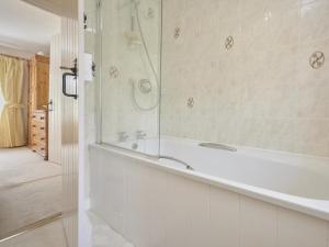 a white bathroom with a tub and a shower at 4 Bed in Keswick oc-sz434 in Applethwaite