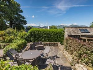 a patio with a table and chairs and a hedge at 4 Bed in Keswick oc-sz434 in Applethwaite