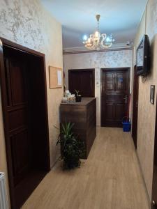 a hallway with a door and a chandelier at Prenociste Aurelia in Subotica +18 photos