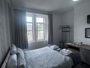 a bedroom with a bed and a window at Glendale Guesthouse in Oban +15 photos