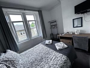 a bedroom with a bed and a desk and a window at Glendale Guesthouse in Oban