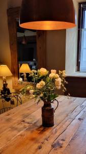 een vaas met bloemen op een houten tafel bij La Tour de la Chapelle - Parking privé in Obernai