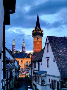 een gebouw met een klokkentoren in een stad bij La Tour de la Chapelle - Parking privé in Obernai +11 foto's