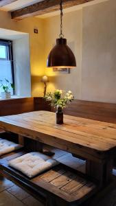 een houten tafel met een vaas met bloemen erop bij La Tour de la Chapelle - Parking privé in Obernai