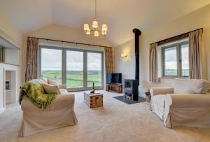 a large living room with two couches and a tv at Barton Barn in Bishops Nympton