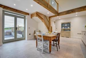 a dining room with a wooden table and chairs at Barton Barn in Bishops Nympton