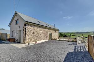 a brick building with a driveway in front of it at Barton Barn in Bishops Nympton
