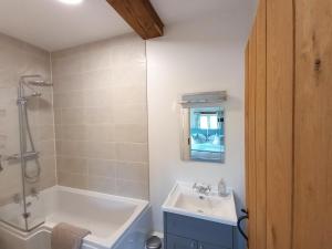 a bathroom with a tub and a sink and a shower at Barton Barn in Bishops Nympton +27 photos