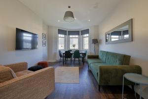 a living room with a couch and a table at The White City Apartment in Oban