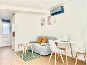 VarreddesにあるRez de Jardin - Calme & Familialeのソファとテーブルと椅子のあるリビングルーム