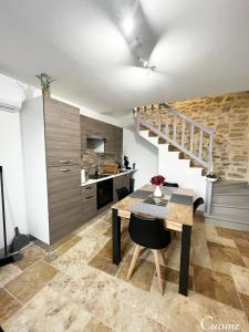 a kitchen and dining room with a table and a staircase at Maison de village rénovée in Lédignan