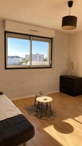 Una habitación con una cama y una mesa dentro. en Studio Bord Loire, en La Riche