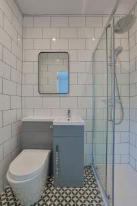 a bathroom with a toilet and a sink and a shower at The White City Apartment in Oban