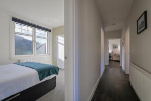 a bedroom with a bed and a window at The White City Apartment in Oban