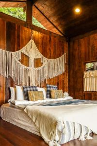 a bedroom with a large bed with a window at ทโล้ โฮมสเตย์ เชียงใหม่ | Taloh Homestay Chiangmai in Mae On
