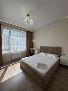 um quarto com uma cama grande e um lustre em GRAND-TURAN Bussiness em Astana