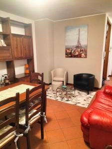 a living room with a red couch and a table at Locazione turistica Gisella  +3 photos