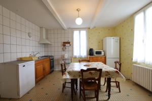 eine Küche mit einem Tisch mit Stühlen und einem Kühlschrank in der Unterkunft Chez brouge in Momas