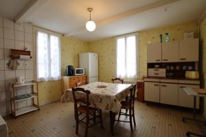 eine Küche mit Tisch und Stühlen und einem Kühlschrank in der Unterkunft Chez brouge in Momas + 20 Fotos