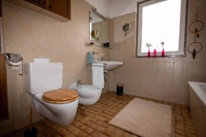 a bathroom with a toilet and a sink and a window at Ferienhaus Kaiser Lothar in Reutte +29 photos