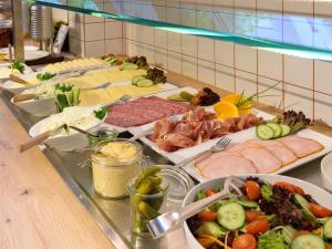 a buffet line with different types of meats and vegetables at ibis budget Hamburg St Pauli Messe - neu renoviert in Hamburg +121 photos