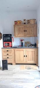 a kitchen with wooden cabinets and a sink at Comme à la maison in Ducey