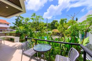 a balcony with a table and chairs and a pool at Sunny Blue Runway in Ban Nai Na