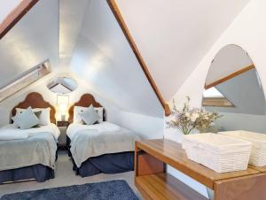 een slaapkamer op zolder met 2 bedden en een tafel bij Warner Wood - Selsey in Selsey +63 foto's
