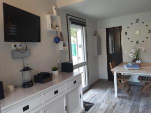 a living room with a tv on top of a dresser at Le cottage de Guidel in Guidel