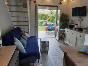 a living room with a blue couch and a patio at Le cottage de Guidel in Guidel