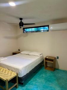 a bedroom with a white bed and a window at La Punta surfhouse in Puerto Escondido