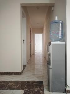 a hallway with a refrigerator with a stack of water bottles on it at Gardenia Hotel in 6th Of October