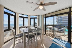 une salle à manger avec une table, des chaises et des fenêtres dans l'établissement Beautiful & Modern Updated Oceanfront Condo for 10! Sedgefield North 103, à Myrtle Beach