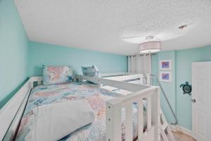 - une chambre avec un lit blanc et des murs bleus dans l'établissement Beautiful & Modern Updated Oceanfront Condo for 10! Sedgefield North 103, à Myrtle Beach 42 autres photos