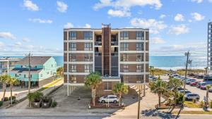 un immeuble d'appartements avec l'océan en arrière-plan dans l'établissement Beautiful & Modern Updated Oceanfront Condo for 10! Sedgefield North 103, à Myrtle Beach