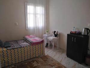 a bedroom with a bed and a window and a table at Gardenia Hotel in 6th Of October