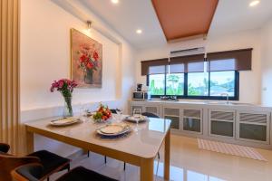 a kitchen with a table with plates and flowers on it at Sunny Blue Runway in Ban Nai Na