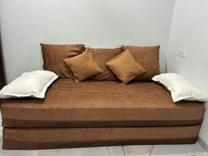 a bed with four pillows on top of it at MP Homestay in Godarpura