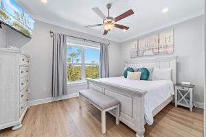 a bedroom with a white bed and a ceiling fan at Waves & Wildlife Getaway at Summer Salt in Orange Beach