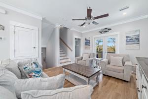 a living room with white walls and a ceiling fan at Waves & Wildlife Getaway at Summer Salt in Orange Beach +52 photos