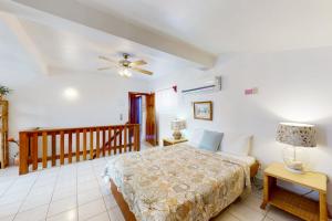 a bedroom with a bed and a ceiling fan at Palm @ Caribe Island in San Pedro +42 photos